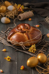 Portuguese traditional Easter cake. Folar with golden eggs on easter table. Blossom flowers and golden painted eggs