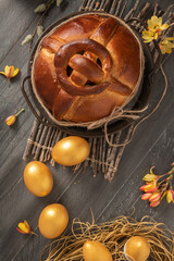 Portuguese traditional Easter cake. Folar with golden eggs on easter table. Blossom flowers and golden painted eggs