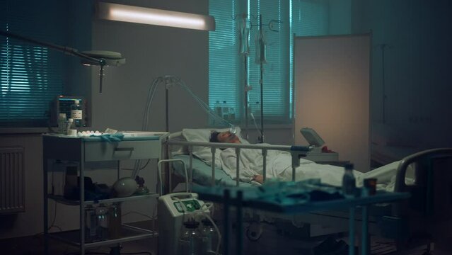Patient lying with oxygen mask in hospital ward. Modern operating room interior.