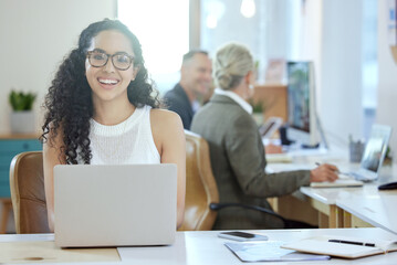 Ive got everything I need right here. Shot of a young businesswoman using a laptop in an office at work.