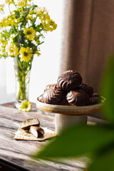 chocolate marshmallow in a composition with yellow flowers and green leaves.