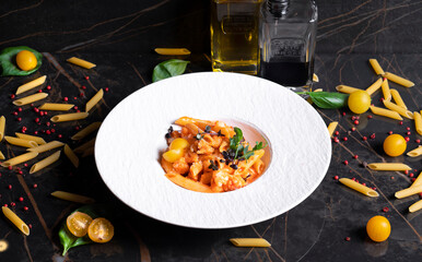 Pasta with vegetables in a white dish on a black background