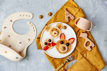 Pancakes With Funny Faces Decorated For Kids. Healthy Fruit Pancakes For baby Meal over wooden background, top view