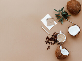 Desktop mockup planner. Flat lay with calendar, blank card,  coffee cup and green olive leaves on brown background. Zero waste, eco friendly, natural organic concept.