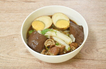 Chinese rice flour paste with pork and entrails topping egg yolk in soup on bowl