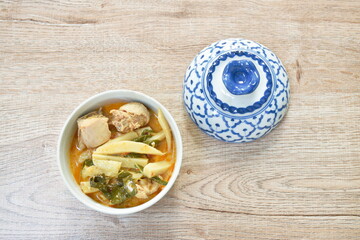 spicy boiled slice fresh bamboo shoot with chicken in coconut milk red curry soup on bowl