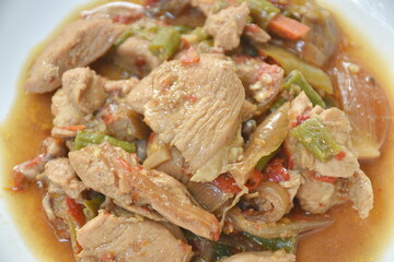 spicy stir fried chicken with slice chili and basil leaf on plate