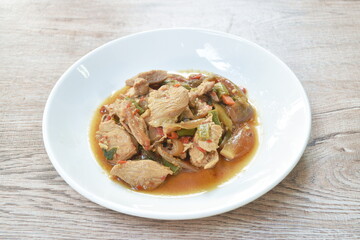 spicy stir fried chicken with slice chili and basil leaf on plate