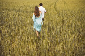 Naklejka na ściany i meble couple walking in a wheat field