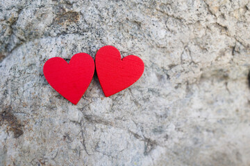 Two red hearts on stone surface . Copy space