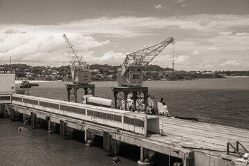 Zwei historische Lastenkräne stehen auf großen Stelzen am Pier des Hafens von Colonia del...