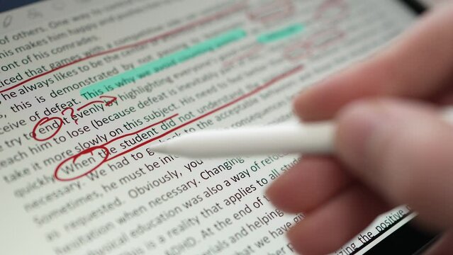Teacher Correcting the Assignment With a Stylus and Tablet