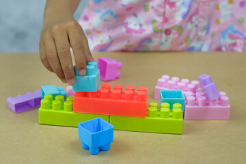 Little girl playing with colorful Bricks