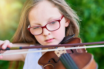 Shes got natural-born musical talent. Cropped shot of a little girl playing the violin outside. © Nikish H/peopleimages.com