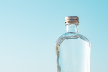 【夏】青空の下の水の入ったガラスボトル
