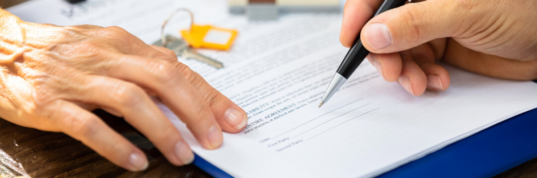 Real Estate Agent Helping Client In Filling Contract Form