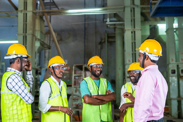 focus on manager, group of industrial workers having fun chat with supervisor at factory - concpet teamwork, collaboration and communication