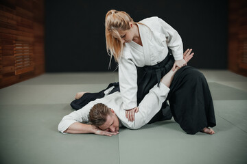 A man and a woman practice aikido indoor - obrazy, fototapety, plakaty