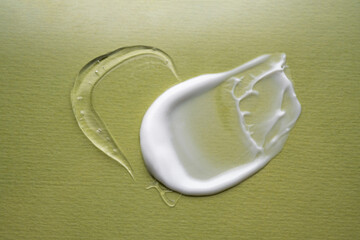 Serum and cream on a green background. Textures.
