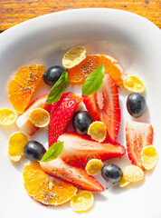 plate with fruit salad and cornflakes