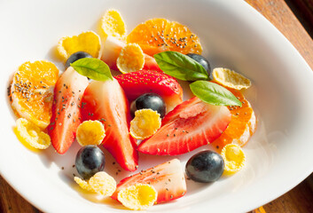 plate with fruit salad and cornflakes