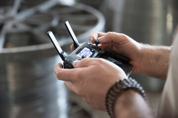 Man holding drone transmitter with attached mobile phone