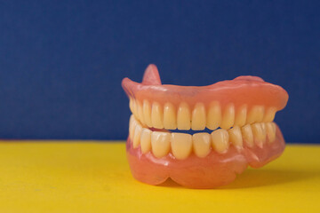 Close-up of removable dentures on a blue background. Dental prosthetics, dental implants. selective focus. Macro.Dental services, dental treatment