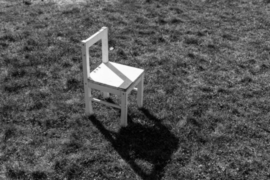 Ein leerer weißer Stuhl steht in der Wiese