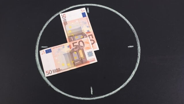 Moving clock hands made from fifty and one hundred dollar bills. Concept time is money. Stop motion animation.