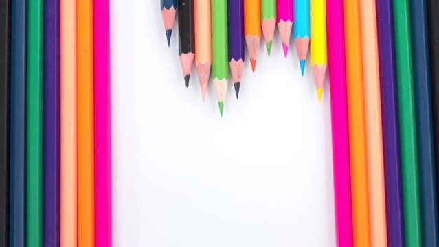 Heart shape on a white background made from multicolored bright wooden pencils with rainbow colors. The concept of love, diversity, joy. Stop motion animation.