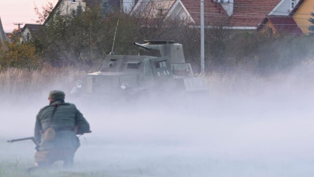 Ukrainian partisans of World War 2 fight against Bolshevik troops. Soviet enemy tank in background. Soldier with a gun sneaks up on the enemy. National liberation struggle of Ukraine
