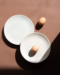 Still life with an egg on a plate. Photos in natural colors. Minimal food concept. Dramatic light and shadows