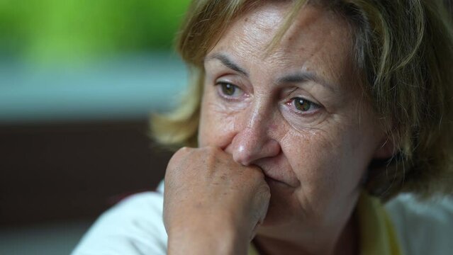 A pensive senior woman closeup face pondering about life