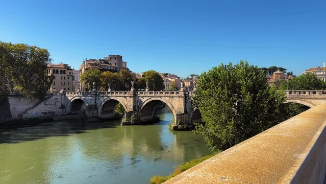Wide shot of historic Aelian Bridge and tranquil Tiber River in Rome during sunny day