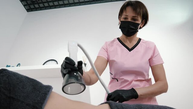 Professional female cosmetologist does hardware vacuum massage of abdomen to young woman. Anti-cellulite body shaping procedure. Vacuum massage of belly copy space