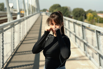 Fototapeta premium Young woman starting new life after car crash accident or heavy illness with morning routine of exercising running and jogging outdoor. Female sport person stretching muscles before workout.