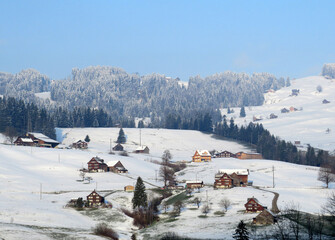 Traditional Swiss architecture and wooden alpine houses in the winter ambience of fresh white snow cover, Nesslau - Obertoggenburg, Switzerland (Schweiz)