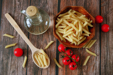 Various types of pasta, Raw pasta set and tomato on wooden background, set
