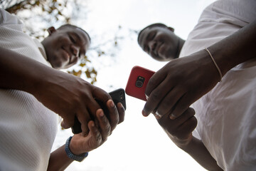 Two young boys use their smartphones together, young generation and technology in Africa