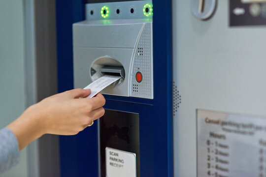 Pay or stay. Cropped shot of an unrecognizable person inserting a ticket into a meter.