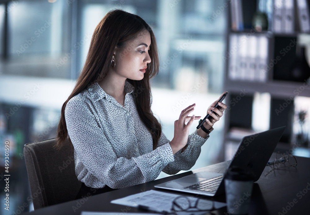 Poster sometimes success requires a bit of extra time. shot of a young businesswoman using a cellphone whil