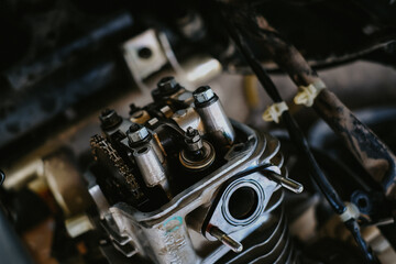 Obraz na płótnie Canvas Set the valve on the cylinder head of the motorcycle engine by a technician.