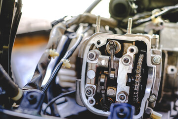 Set the valve on the cylinder head of the motorcycle engine by a technician.