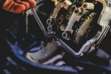Set the valve on the cylinder head of the motorcycle engine by a technician.