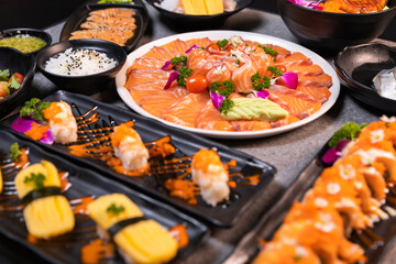 Sashimi sushi set with soy on black background.Assorted sushi set served on dark stone slate background. Top view