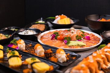 Sashimi sushi set with soy on black background.Assorted sushi set served on dark stone slate background. Top view