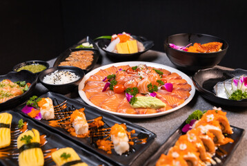 Sashimi sushi set with soy on black background.Assorted sushi set served on dark stone slate background. Top view