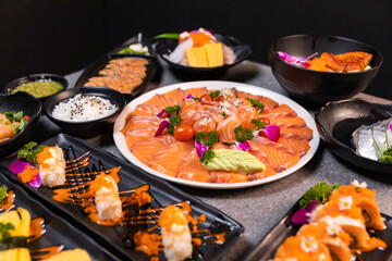 Sashimi sushi set with soy on black background.Assorted sushi set served on dark stone slate background. Top view