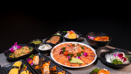 Sashimi sushi set with soy on black background.Assorted sushi set served on dark stone slate background. Top view