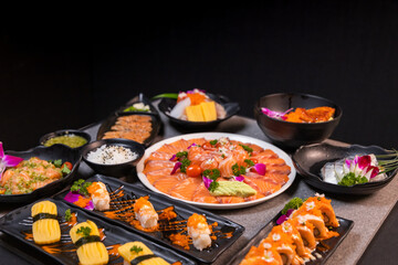 Sashimi sushi set with soy on black background.Assorted sushi set served on dark stone slate background. Top view